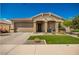 Tan house with a two-car garage and landscaping at 42162 W Palmyra Ct, Maricopa, AZ 85138