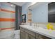 Stylish bathroom with orange and gray tile, a gray vanity and a white sink at 19980 E El Nido Ln, Litchfield Park, AZ 85340
