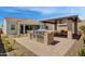 Outdoor kitchen and covered patio with built-in grill and seating area at 19980 E El Nido Ln, Litchfield Park, AZ 85340