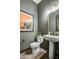 Elegant powder room with a pedestal sink, white toilet, and dark green walls at 19980 E El Nido Ln, Litchfield Park, AZ 85340