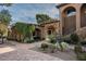 Stone and stucco home with lush landscaping and a courtyard entry at 23036 N Via Ventosa Dr, Scottsdale, AZ 85255