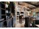 Long bar, stone wall, dark cabinetry, and a lounge area at 23036 N Via Ventosa Dr, Scottsdale, AZ 85255