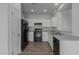Modern kitchen with white cabinets, black appliances, and granite countertops at 812 E Agua Fria Ln, Avondale, AZ 85323