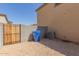 Backyard with gravel, a wooden gate, and a blue bin at 812 E Agua Fria Ln, Avondale, AZ 85323