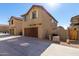 Two-story tan house with brown garage door and driveway at 836 E Agua Fria Ln, Avondale, AZ 85323