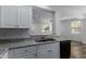 Kitchen with white cabinets, granite countertops, and a view of the living room at 851 E Agua Fria Ln, Avondale, AZ 85323