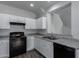 Modern kitchen with white cabinets, black appliances and granite countertops at 851 E Agua Fria Ln, Avondale, AZ 85323