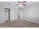 Spacious bedroom with carpet, ceiling fan, and mirrored closet doors at 927 E Agua Fria Ln, Avondale, AZ 85323