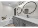 Modern bathroom with gray double vanity and soaking tub at 10103 E Plata Ave, Mesa, AZ 85212