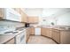 Kitchen with wood cabinets, white appliances, and a corner sink at 3408 W Sands Dr, Phoenix, AZ 85027