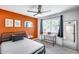 Bright bedroom with orange accent wall, desk workspace, and modern bed at 2616 S Extension Rd, Mesa, AZ 85210