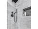 Modern shower with black fixtures and pebble tile accent wall at 2616 S Extension Rd, Mesa, AZ 85210