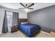 Cozy bedroom with a full bed, ceiling fan, and gray accent wall at 2616 S Extension Rd, Mesa, AZ 85210