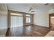 Spacious living room featuring hardwood floors, a ceiling fan, and access to the backyard at 10801 W Palm Ln, Avondale, AZ 85392