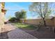 Private backyard with a grassy area, mature trees and a brick pathway at 20377 W Terrace Ln, Buckeye, AZ 85396