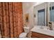 Clean bathroom with a toilet, sink, and patterned shower curtain at 20377 W Terrace Ln, Buckeye, AZ 85396