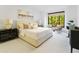 Primary bedroom with large windows, plush bedding and sitting area at 7175 E Camelback Rd # 202, Scottsdale, AZ 85251