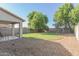 Large backyard with grassy area, gravel, and covered patio at 794 E Christopher St, San Tan Valley, AZ 85140