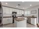 White kitchen with stainless steel appliances and an island at 794 E Christopher St, San Tan Valley, AZ 85140