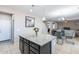 Kitchen island with granite countertop, dark cabinets and view into living area at 4724 W Lydia Ln, Laveen, AZ 85339