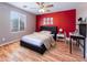 Bright bedroom with wood floors, and red accent wall at 42331 W Somerset Dr, Maricopa, AZ 85138