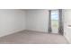 Bright bedroom featuring a window with patterned curtains and carpet at 14852 S Diablo Rd, Arizona City, AZ 85123