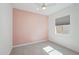 Bedroom with light pink accent wall and wood-look floors at 13190 W Horsetail Trl, Peoria, AZ 85383