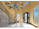 Grand entryway with a stone staircase and an ornate chandelier at 8876 S Santa Elizabeth Dr, Goodyear, AZ 85338