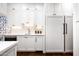 Modern kitchen boasts white cabinets and built-in refrigerator at 24546 N 91St St, Scottsdale, AZ 85255