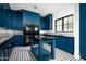 Bright laundry room with teal cabinets, black countertops, and patterned tile floors at 24546 N 91St St, Scottsdale, AZ 85255