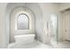 Elegant bathroom featuring a freestanding tub, a walk-in shower, and a mosaic tile accent wall at 24546 N 91St St, Scottsdale, AZ 85255