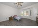 Bright bedroom with bay window, ceiling fan, and wood-look floors at 15574 W Vista Grande Ln, Surprise, AZ 85374