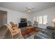 Bright living room with comfy seating, a large TV, and a ceiling fan at 15574 W Vista Grande Ln, Surprise, AZ 85374