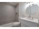 Updated bathroom with gray tile shower, white vanity, and a round mirror at 1331 E Pierson St, Phoenix, AZ 85014