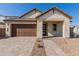 Modern house with light-colored stone facade and brown garage door at 21354 E Sparrow Dr, Queen Creek, AZ 85142