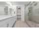 Bathroom with double vanity, walk-in shower, and large mirror at 21354 E Sparrow Dr, Queen Creek, AZ 85142
