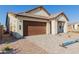 New construction home with brown garage door and stone accents at 21354 E Sparrow Dr, Queen Creek, AZ 85142