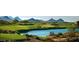 Aerial view of a community with a golf course, lake, and mountain views at 40575 N 109Th Pl, Scottsdale, AZ 85262