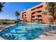 Community pool with surrounding lounge chairs and patio umbrellas at 4303 E Cactus Rd # 441, Phoenix, AZ 85032