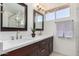 Double vanity bathroom with dark wood cabinets and a large mirror at 5725 E Evans Dr, Scottsdale, AZ 85254