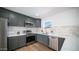 Modern kitchen with dark gray cabinets, quartz countertops, and stainless steel appliances at 1642 W Capri Ave, Mesa, AZ 85202
