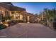 Night view of a luxury home's exterior with stone facade and desert landscaping at 10184 E Peak Cir, Scottsdale, AZ 85262