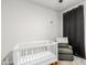 Bedroom featuring crib, armchair, and dark curtains at 20442 E Rosa Rd, Queen Creek, AZ 85142