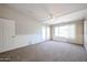 Bright bedroom with carpet, double doors to a patio, and a ceiling fan at 2448 E Fiesta Dr, Casa Grande, AZ 85194
