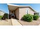 Front view of tan mobile home with walkway and landscaping at 11596 W Sierra Dawn Blvd # 36, Surprise, AZ 85378