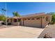 Tan single-story house with a two-car garage and large driveway at 9821 N 103Rd Ave, Sun City, AZ 85351