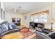 Cozy living room with a comfortable leather sofa, built-in bookshelves, and hardwood flooring at 518 N Home Pl, Chandler, AZ 85224