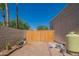 Backyard features a wooden gate and ample space for storage at 3731 E Equestrian Trl, Phoenix, AZ 85044