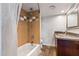 Clean bathroom with tub, shower, granite vanity and brown cabinets at 207 W Clarendon Ave # 20B, Phoenix, AZ 85013