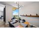 Modern dining area with city views, wood table, and teal chairs at 207 W Clarendon Ave # 20B, Phoenix, AZ 85013
